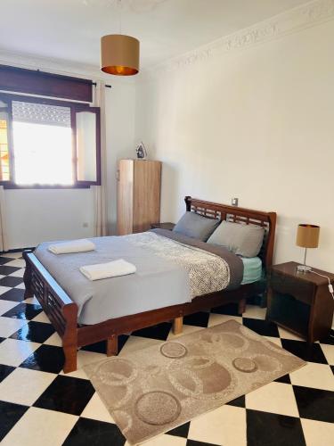 a bedroom with a bed and a checkered floor at Blue Pearl city in Chefchaouene