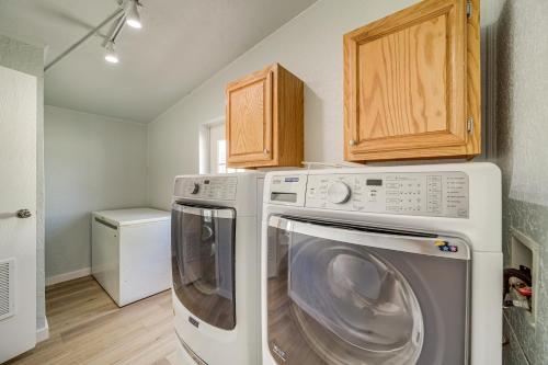 a laundry room with a washer and dryer and wooden cabinets at Walk to Beach Eufaula Fishermans Delight Home in Eufaula