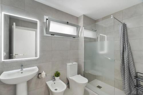 a white bathroom with a sink and a toilet at Apartamento Iris in Igueste