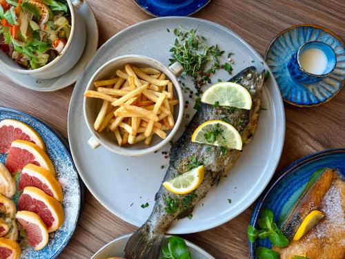 a table with plates of food with fish and french fries at Hotel Rzemieślnik Zakopane in Zakopane