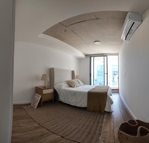 a bedroom with a bed and a large window at Sudestada Apartamentos Turisticos in Punta del Este