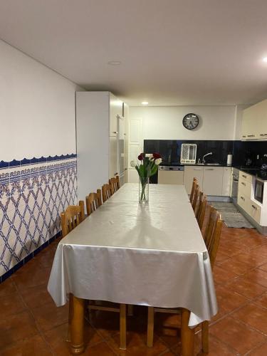 a dining room table with a vase of flowers on it at Nature & Family Guesthouse in Louredo
