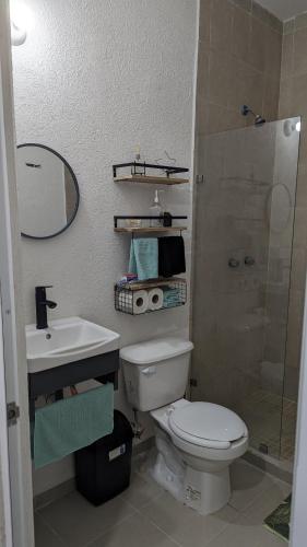 a bathroom with a toilet and a sink and a shower at Casa de Vacaciones in Cancún