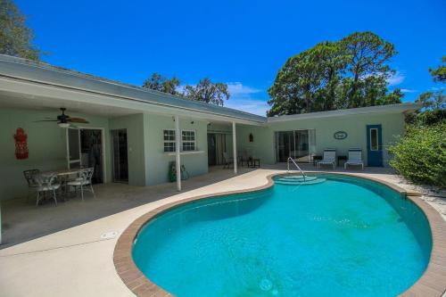 a swimming pool in front of a house at Beautiful 3 BR pool home minutes from Siesta Key - Blue Dolphin in Sarasota