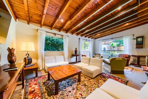 a living room with white furniture and a wooden ceiling at Apartur Catedral in San Carlos de Bariloche