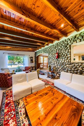 a living room with white couches and a stone wall at Apartur Catedral in San Carlos de Bariloche