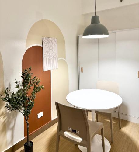una sala da pranzo con tavolo e sedie bianche di Meraki Stays - ETANA - SMDC Hope Residences a Trece Martires