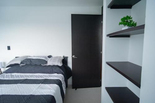 a bedroom with a bed and a black door at EXCELENTE CONJUNTO, UBICACION PRIVILEGIADA, Torre 3 in Armenia