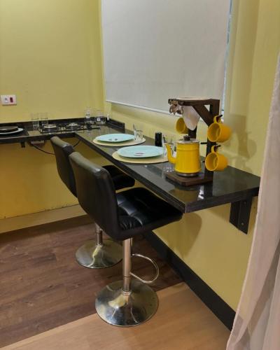 a black table with two chairs in a room at Chácara Itaqueri Topázio in São Pedro