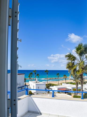 a view of the beach from the balcony of a resort at Villa Margo by the Sea in Paphos City