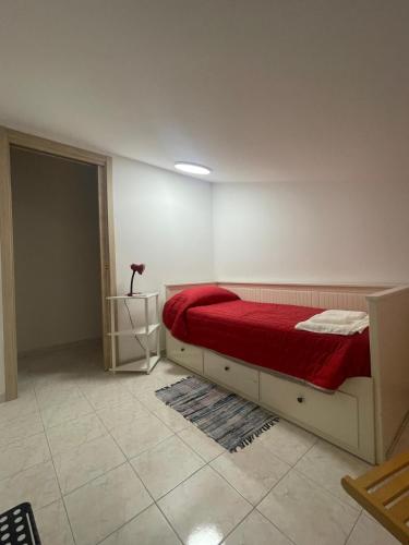 a bedroom with a bed with a red blanket at La Mansarda in Foiano di Val Fortore