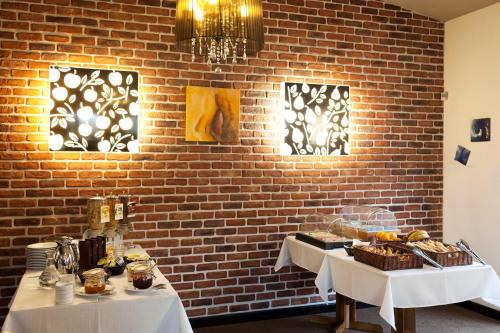 a brick wall with two tables with food on them at Hôtel Le Verger De Bischwiller in Bischwiller