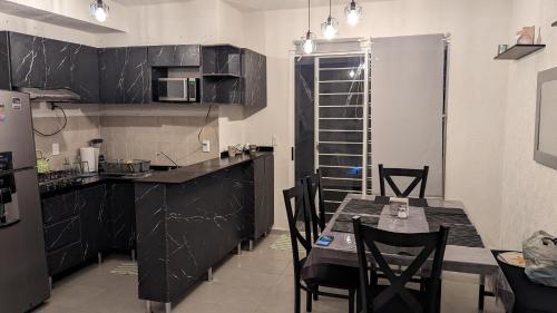 a kitchen with a table and chairs in a room at Casa de Vacaciones in Cancún