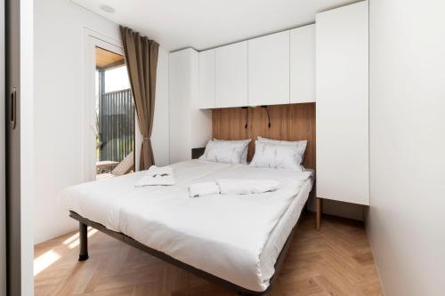 una camera da letto con un grande letto bianco e armadi bianchi di Mobile Homes Casapini in FKK Camping Solaris a Poreč (Parenzo)