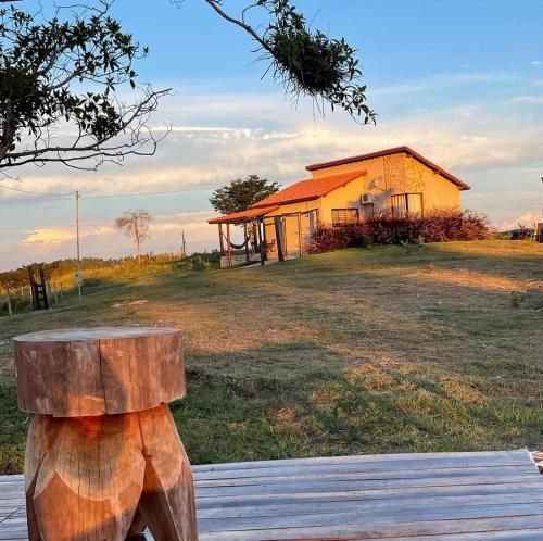 un banc en bois assis devant un bâtiment dans l'établissement Bangalô de Pedras, à São Thomé das Letras