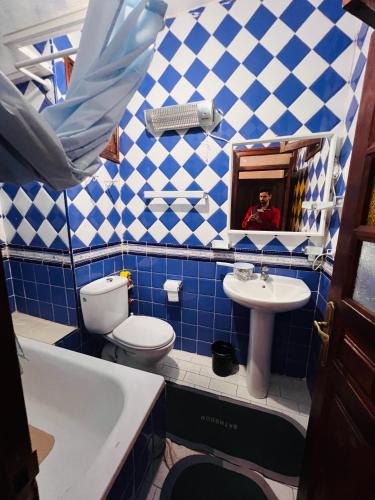 a blue and white bathroom with a toilet and a sink at Blue Pearl city in Chefchaouene