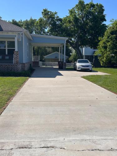 a driveway with a car parked in front of a house at 3 Bed, 2 and a half bath Gorgeous Coastal Home 1 block from beach! in Long Beach