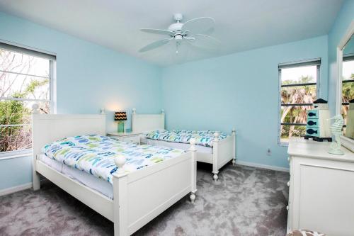 YbelにあるCharming Sanibel Island Home Minutes From The Beachの青い壁と窓が特徴のベッドルーム1室(ベッド2台付)