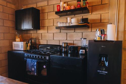 a kitchen with a black stove and a refrigerator at House Terravid in Ensenada