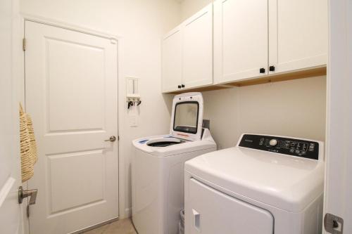 a white laundry room with a washer and dryer at Serene lakefront pool home in Lorraine Lakes - Coral Paradise in Bradenton