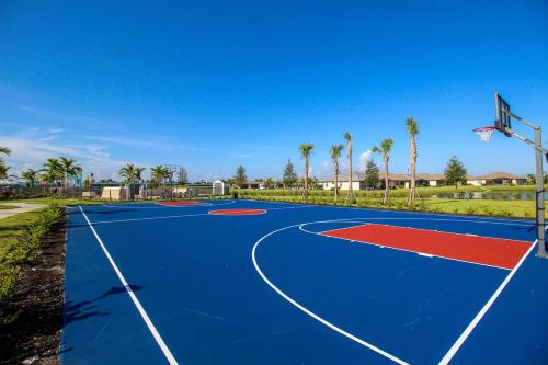 a blue and red basketball court with a hoop at Serene lakefront pool home in Lorraine Lakes - Coral Paradise in Bradenton
