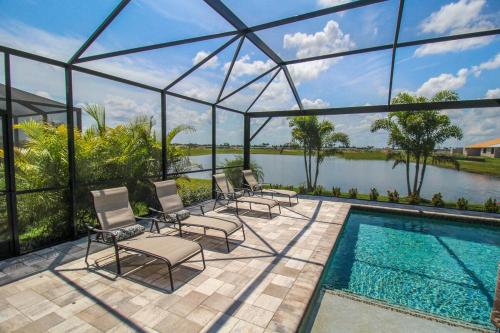 a group of chairs sitting next to a swimming pool at Serene lakefront pool home in Lorraine Lakes - Coral Paradise in Bradenton