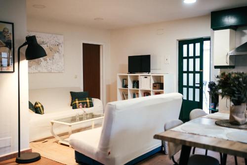a living room with a white couch and a table at Casa Milladoiro in Miño