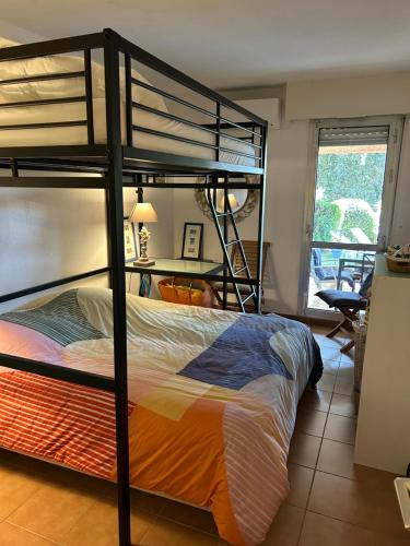 une chambre avec deux lits superposés et un bureau dans l'établissement Appartement Valescure au cœur des golfs, à Saint-Raphaël