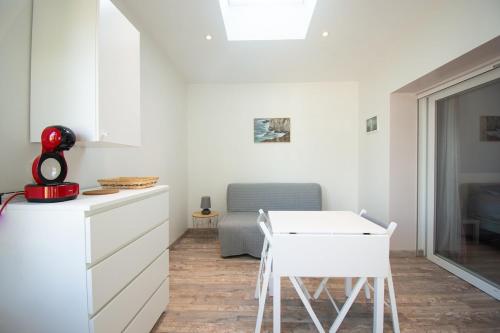 - une cuisine blanche avec une table et une chaise dans l'établissement Le Petit Moulin I Plage et terrasse, à Crozon