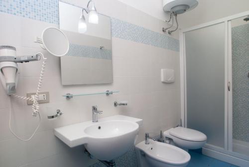 a bathroom with a sink and a toilet and a mirror at Villaggio Turistico La Mantinera - Residence in Praia a Mare