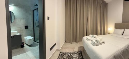 a bedroom with a white bed and a bathroom at Lux Level 4 Penthouse Tower 206 in Nicosia