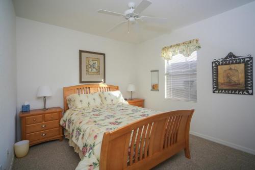 une chambre avec un lit et un ventilateur de plafond dans l'établissement Golfer's paradise in resort style Heritage Harbour, à Bradenton