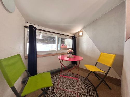 - une petite table et deux chaises dans une chambre avec fenêtre dans l'établissement Studio Tamaris aux pieds des Arènes, à Arles