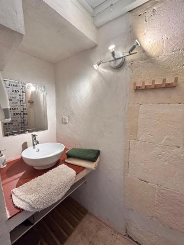 une salle de bain blanche avec un lavabo et un miroir dans l'établissement Studio Tamaris aux pieds des Arènes, à Arles