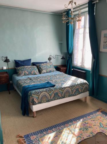 une chambre avec un lit aux murs bleus dans l'établissement Aux lapins Bleus, à La Ferté-Vidame