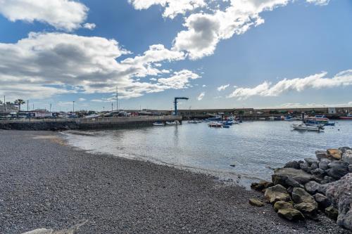 a beach with boats in the water and a bridge at Apartamento Estrella in Candelaria