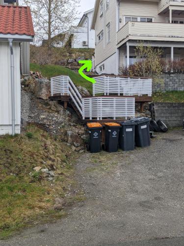 a bunch of trash cans in front of a house at Loftsleilighet,havutsikt,balkong,gratis parkering in Tromsø