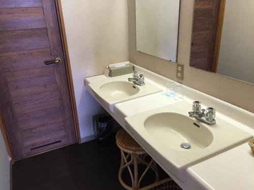 a bathroom with a white sink and a mirror at Nasu Onsen Sanraku in Nasu