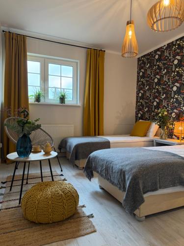 a bedroom with two beds and a table at Potęgówka wege Kaszuby in Linia
