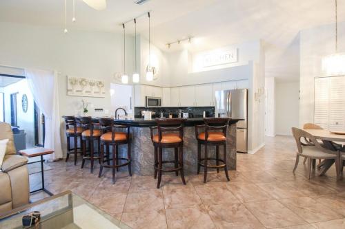 a kitchen with a bar with bar stools at Elegant 3BR 2BA Private Pool Home in Palmetto