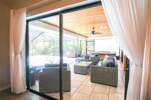 a living room with sliding glass doors and a patio at Elegant 3BR 2BA Private Pool Home in Palmetto