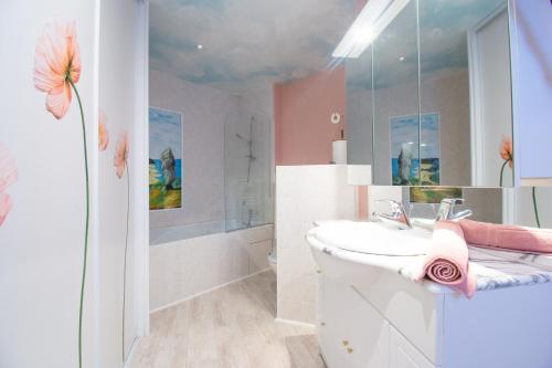 a white bathroom with a sink and a shower at Le Petit Moulin I Plage et terrasse in Crozon