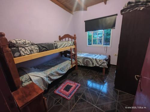 a room with two bunk beds and a window at La posada del iguazu in Puerto Iguazú