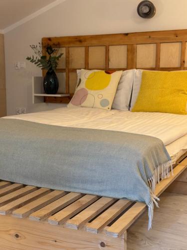 a bed with a wooden frame with a blanket on it at Potęgówka wege Kaszuby in Linia