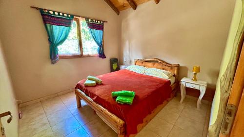 1 dormitorio con 1 cama y 2 toallas verdes en Chacra CheSuiza, en Epuyén