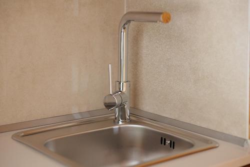 a kitchen sink with a faucet on the wall at Galatia Studios and Apartments in Benitses