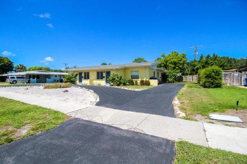 a driveway leading to a yellow house at 1BR Venice home with private beach access - Golden Beach Haven in Venice