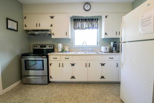 a kitchen with white cabinets and a white refrigerator at 1BR Venice home with private beach access - Golden Beach Haven in Venice