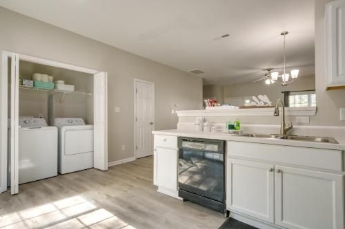 a kitchen with white cabinets and a sink and a dishwasher at Pets Welcome Townhome with Patio in Raleigh! in Raleigh
