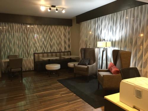 a waiting room with a chair and a table at Baymont by Wyndham Rocky Mount I-95 in Rocky Mount